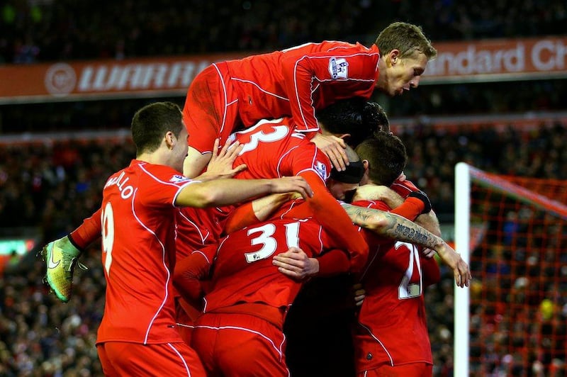 Adam Lallana of Liverpool celebrates with teammates after scoring his team's second goal in their 4-1 Premier League victory over Swansea City on Monday night at Anfield. Clive Brunskill / Getty Images / December 29, 2014 