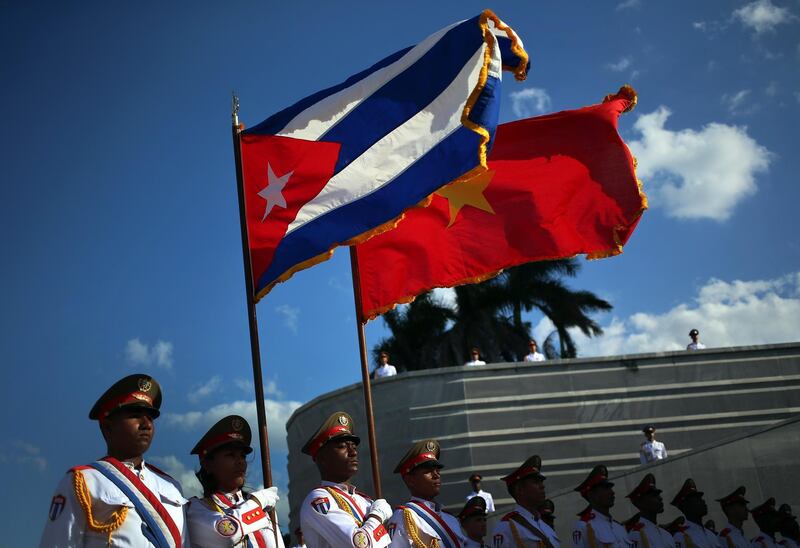 Cuban soldiers hold the national flags of Cuba and Vietnam during a ceremony for the visiting Secretary-General of Vietnam Communist Party Nguyen Phu Trong.  Alejandro Ernesto / EPA