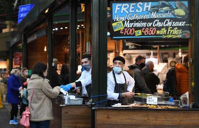 epa08804387 Customers at a paella stall at Borough Market during the national lockdown in London, Britain, 07 November 2020. The UK has begun its second national lockdown. This comes as news reports state that Covid-19 related deaths in Britain have increased by forty six percent in less than a week.  EPA/ANDY RAIN