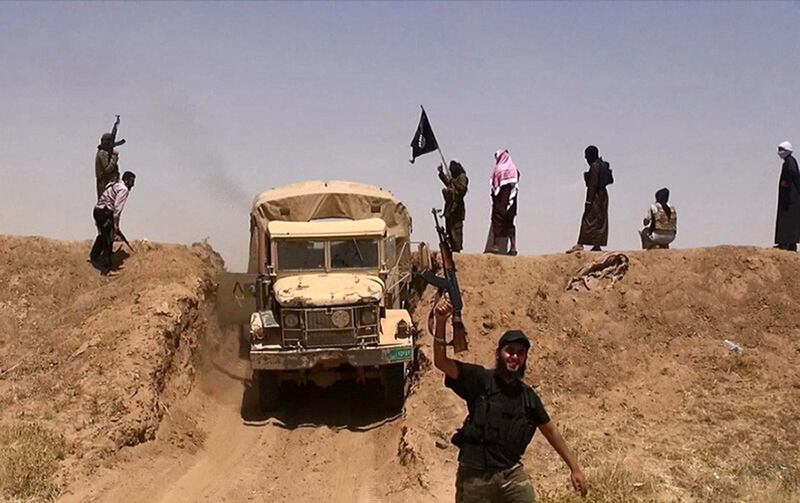An image made available by the jihadist Twitter account Al-Baraka news on June 11, 2014 allegedly shows militants of the jihadist group Islamic State of Iraq and the Levant (ISIL) waving the Islamic Jihad flag and holding up their weapons as a vehicle drives on a newly cut road through the Syrian-Iraqi border between the Iraqi Nineveh province and the Syrian town of Al-Hasakah. AFP PHOTO / HO / ALBARAKA NEWS
=== RESTRICTED TO EDITORIAL USE - MANDATORY CREDIT "AFP PHOTO / HO / ALBARAKA NEWS" - NO MARKETING NO ADVERTISING CAMPAIGNS - DISTRIBUTED AS A SERVICE TO CLIENTS === (Photo by - / ALBARAKA NEWS / AFP)
