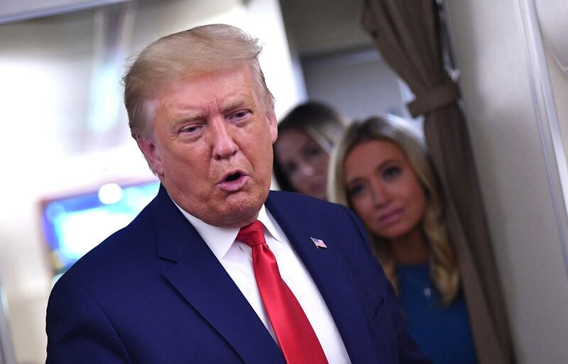 US President Donald Trump, flanked by White House Press Secretary Kayleigh McEnany, speaks to reporters onboard Air Force One after a campaign rally in Mosinee, Wisconsin on September 17, 2020. / AFP / MANDEL NGAN
