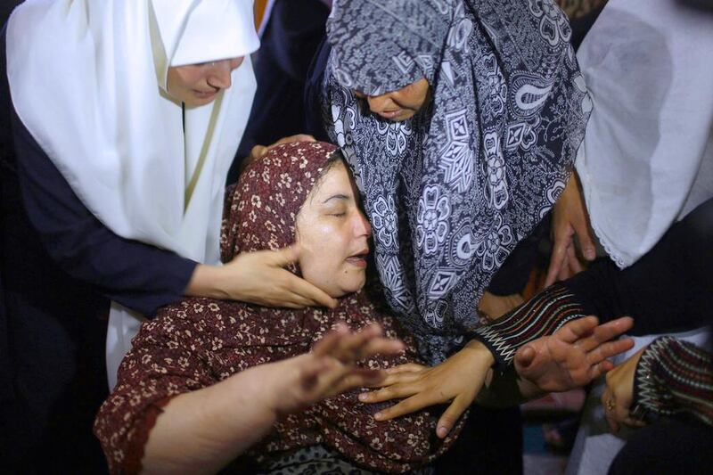 The mother of Zuheir Al Dawawseh, 10, who was killed in an Israeli airstrike, is comforted during his funeral in Gaza City on August 8, 2014. Suhaib Salem / Reuters