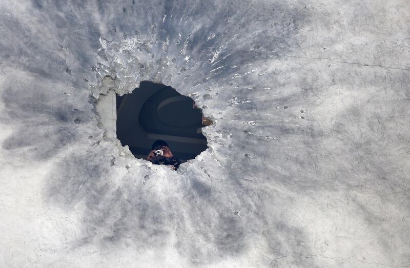 A security officer inspects a rocket hole in a private building in downtown Kabul, Afghanistan. According to media reports at least one person was killed and three others were injured as several rockets landed on the Afghann capital.  EPA