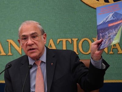 Jose Angel Gurria, secretary-general of the Organisation for Economic Co-operation and Development (OECD), displays a leaflet that reads "Japan: Promoting inclusive Growth for an Ageing Society" while delivering his opening speech during a press conference at the Japan National Press Club in Tokyo on April 13, 2018. / AFP PHOTO / Toshifumi KITAMURA