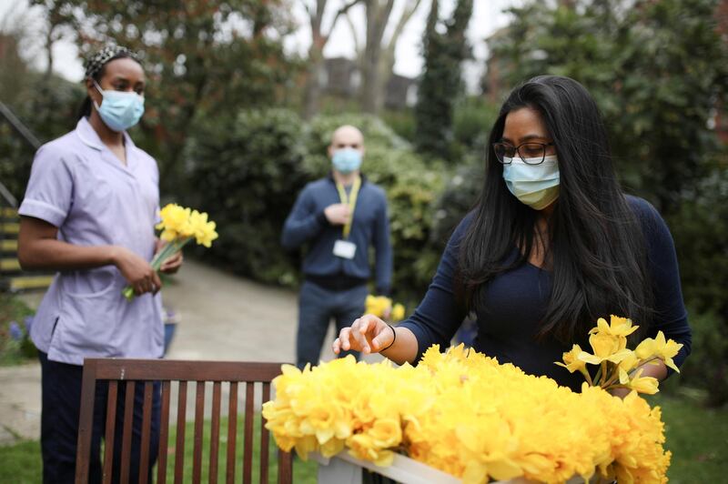 A staff member takes daffodils during the day of reflection at the Marie Curie Hospice in Hampstead, in London. Reuters