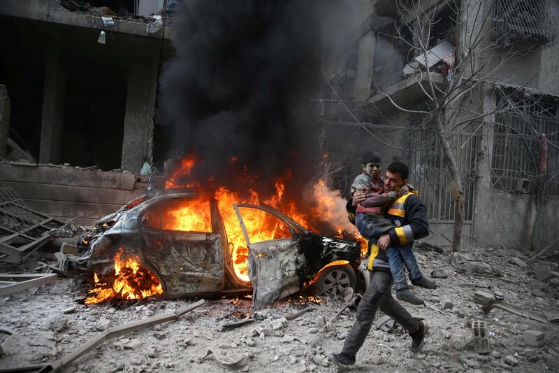 A Syria Civil Defence member carries a wounded child in the besieged town of Hammuriyeh, Eastern Ghouta, in Damascus, Syria on January 6, 2018. Bassam Khabie / Reuters