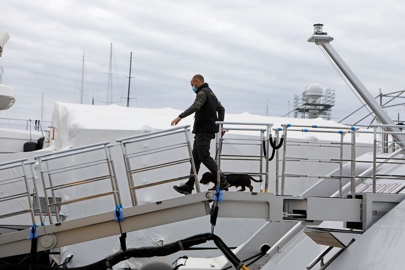 A civil guard and a police dog walk off the yacht. AP