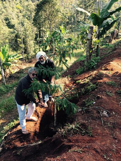 Ibrahim, left, and artist Vivek Vilasini plant an Indian gooseberry tree in honour of Hassan Sharif, in Munnar, India, in 2016. Photo: Vivek Vilasini