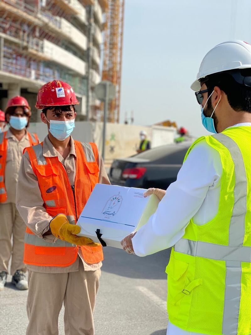 Abu Dhabi Municipality staff distribute clothes and food to workers before Eid Al Adha. Abu Dhabi Municipality