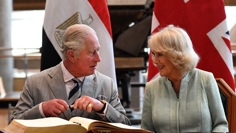 Britain's Prince Charles, the Prince of Wales, accompanied by his wife Camilla, Duchess of Cornwall, sign the guestbook during their visit to the Bibliotheca Alexandrina. AFP