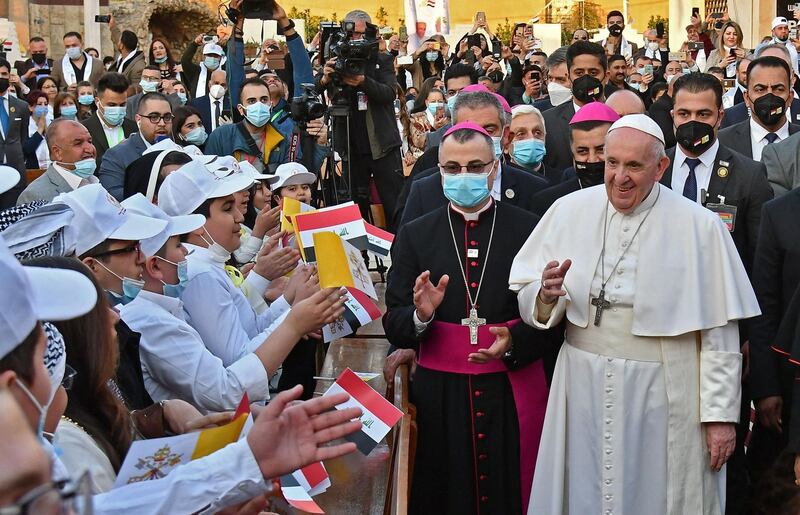 Pope Francis is greeted by children upon his arrival at Baghdad's Saint Joseph Cathedral. AFP