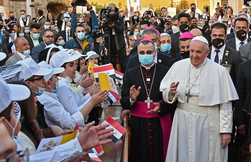 Pope Francis is greeted by children upon his arrival at Baghdad's Saint Joseph Cathedral. AFP