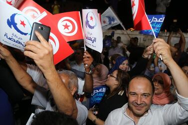 Suppoters of the Tunisian Islamist-inspired Ennahdha party celebrate in reaction to the first exit polls in front of the party's office in the capital Tunis. AFP 