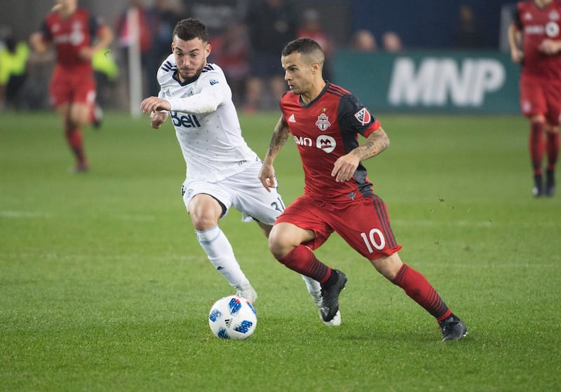 Oct 6, 2018; Toronto, Ontario, CAN; Toronto FC forward Sebastian Giovinco (10) battles for a ball with Vancouver Whitecaps midfielder Russell Teibert (31) during the second half at BMO Field. Mandatory Credit: Nick Turchiaro-USA TODAY Sports