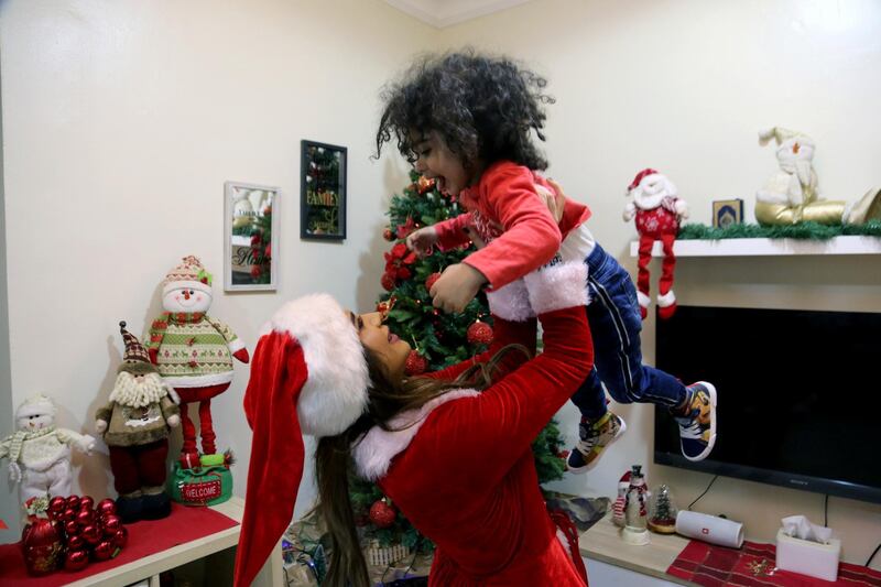 Lamees Homidan, a Lebanese Christian dressed as Santa Claus, plays with her child at her home, during Christmas season, in Riyadh, Saudi Arabia.  Reuters