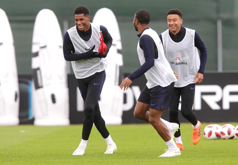 England's Marcus Rashford holds a toy chicken during a drill with Raheem Sterlingand Jesse Lingard during the training session. Getty Images