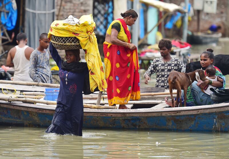 Residents move their belongings to drier ground in the Daraganj area of Allahabad. AFP