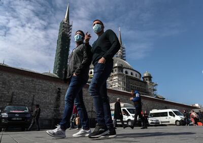 epa08285912 People  wearing a face mask while background seen Taksim Mosque at Taksim Square in Istanbul, Turkey, 11 March 2020. Turkish Health Minister Fahrettin Koca announced the first coronavirus COVID-19 case in Turkey of a male patient who tested positive and was isolated.  EPA/SEDAT SUNA