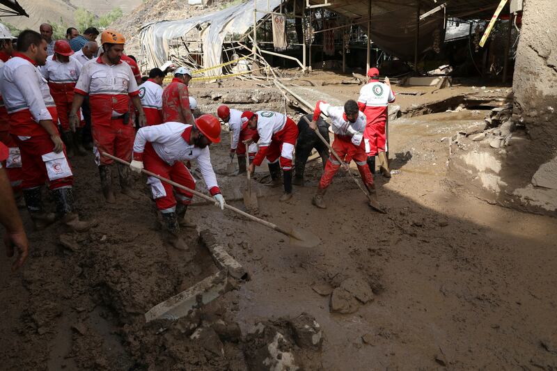 Rescue workers clean up the village after the flooding. AP Photo