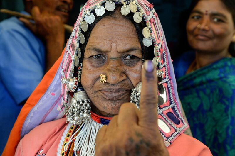 An Indian lambadi tribeswoman shows her ink-marked finger after voting at a polling station at Pedda Shapur village on the outskirts of Hyderabad. AFP