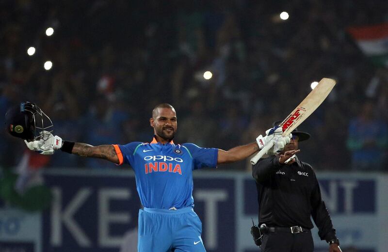 India's Shikhar Dhawan raises his bat and helmet to celebrate scoring a century during their third and final one-day international cricket match against Sri Lanka in Visakhapatnam, India, Sunday, Dec. 17, 2017. (AP Photo/Aijaz Rahi)