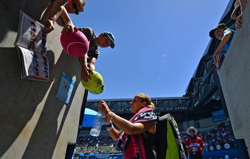 Dominika Cibulkova of Slovakia signs autographs following her victory over Francesca Schiavone of Italy. Saeed Khan / AFP