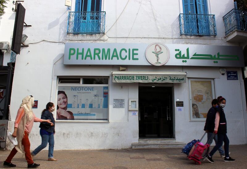 People walk past a pharmacy, amid concerns over the spread of Covid-19 in Tunis, Tunisia. Reuters