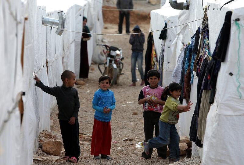Syrian children play outside their tents at a refugee camp in the city of Arsal in Lebanon’s Bekaa valley on March 28, 2014. Lebanon has in the past three years become home to nearly one million people who have fled Syria’s civil war. Joseph Eid / AFP