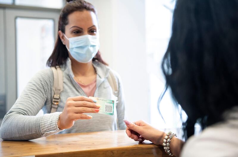 A woman shows her vaccination certificate at the reception of a gym in Nyiregyhaza, Hungary. EPA