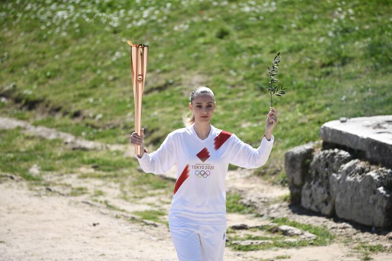 Torchbearer Greece's Anna Korakaki, Rio 2016 gold medallist in the 25m pistol shooting, holds the Olympic flame and an olive branch during the flame lighting ceremony. AFP