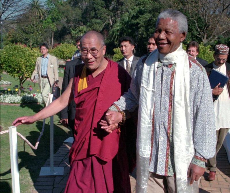 Mandela with the Dalai Lama, left, walks hand-in-hand with South African President Nelson Mandela prior to an official reception at the presidential office in Cape Town, South Africa. Sasa Kralj / AP Photo