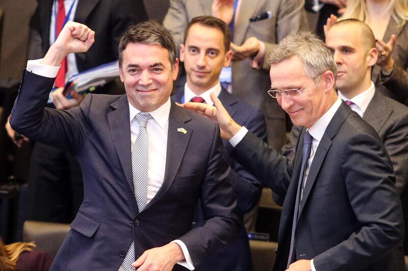 Macedonian Foreign Minister Nikola Dimitrov (L) makes a fist as he stands along side NATO Secretary General Jens Stoltenberg following the signing ceremony of the accession protocol between the Republic of North Macedonia and NATO at the Alliance headquarters in Brussels on February 6, 2019. Macedonia signed accession papers with NATO, a key step on the way to joining the  alliance after resolving a long-running name row with Greece. The Macedonian Foreign Minister Nikola Dimitrov and representatives of all current NATO members signed the protocol at alliance headquarters in Brussels.
 / AFP / François WALSCHAERTS
