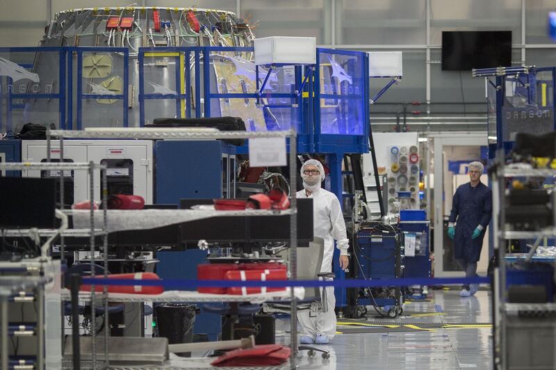 Engineers inside a clean room help construct the Crew Dragon spacecraft. AFP