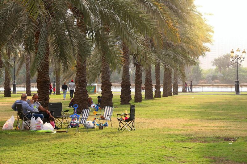 KYW2FT SHARJAH, UAE - DECEMBER 10, 2017: People visit Al Nakheel Oasis park with palm trees in Sharjah, UAE. This third populous city of UAE is the capital o