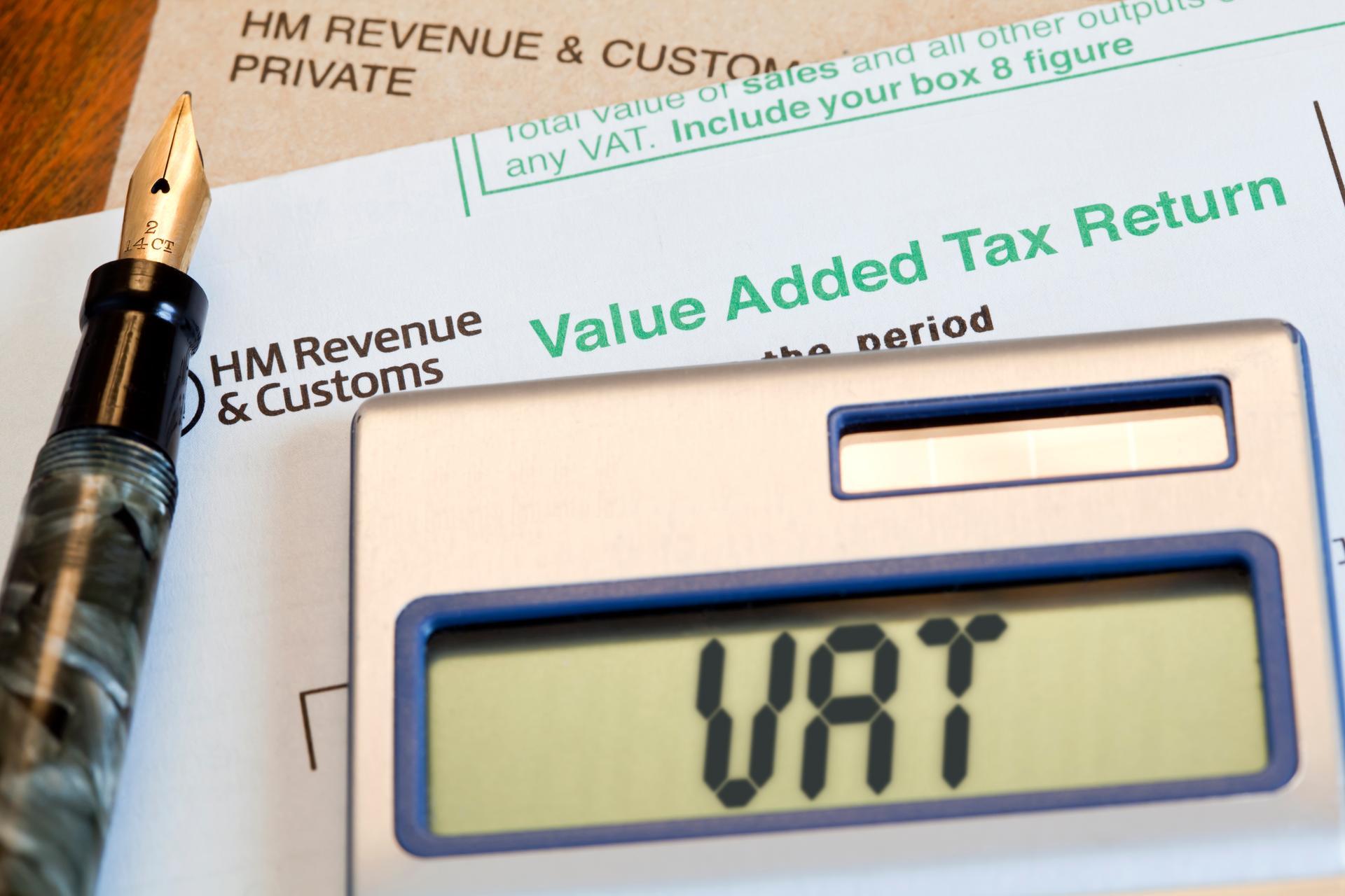 "UK VAT, Value Added Tax form, for Her Majestyaas Revenue & Customs, with a calculator, manilla brown envelope and antique fountain pen on a desktop. VAT, or Value added Tax, is a tax on the purchase price of goods and services. The tax is paid to the government by registered businesses and is the sale price of the goods or services, minus the cots of materials and other taxable inputs. In most cases this tax is paid quarterly per annum." Getty Images