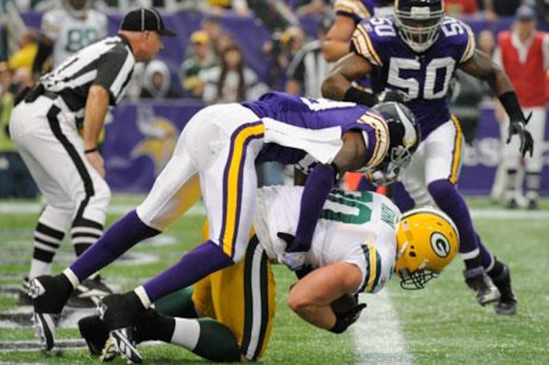 Husain Abdullah of the Minnesota Vikings gets taken for a ride into the end zone by John Kuhn of the Green Bay Packers.