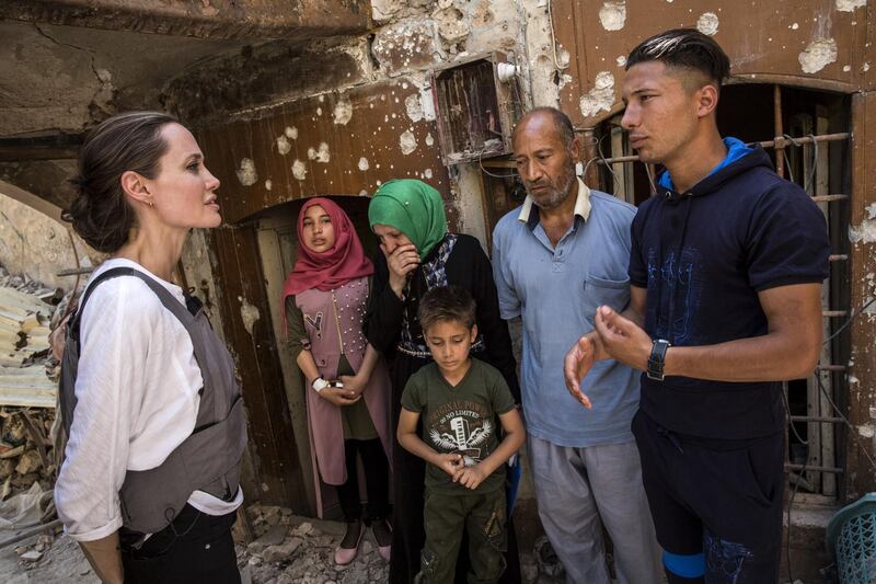MOSUL, IRAQ - JUNE 16: (EDITORIAL USE ONLY) In this handout image provided by United Nations High Commission for Refugees, UNHCR Special Envoy Angelina Jolie meets with Mohamed and his family during a visit to the Old City in West Mosul during a visit to Iraq, on June 16, 2018. During the offensive to retake the city from ISIS Mohamed's house was hit by an airstrike killing his 17 year-old daughter and destroying most of the home. Together with his three surviving children and his wife, Mohamed fled to the home of a family friend, where they have been living ever since. However the host family can no longer support them and Mohamed may have to bring his family back to live in the ruins of their home. Less than a year after its liberation, much of West Mosul still lies in ruins. (Photo by Andrew McConnell / UNHCR via Getty Images)