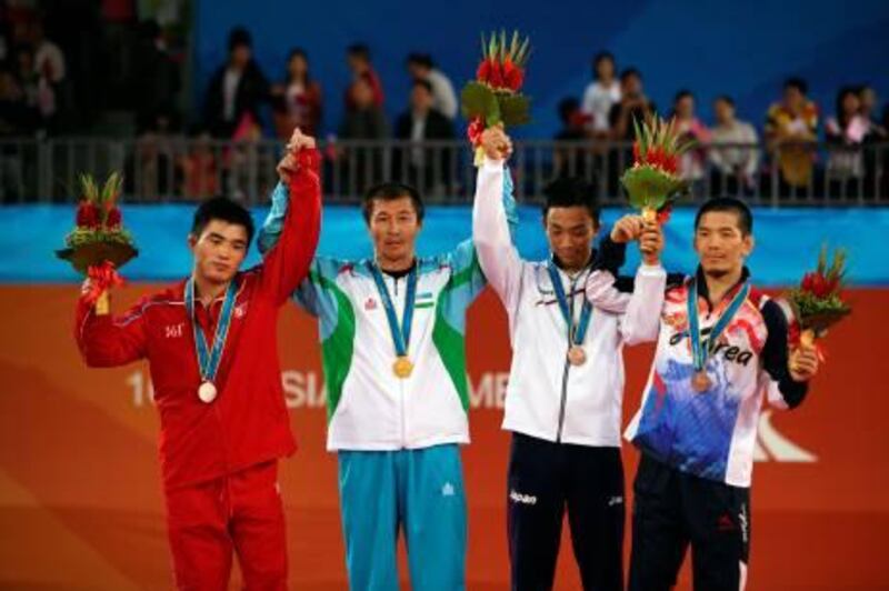 Gold medallist Dilshod Mansurov of Uzbekistan(2nd- L), silver winner Yang Kyong il of North Korea (L) and the two bronze medallists Kim Hyosub (R) of South Korea and Yasuhiro Inaba of Japan pose on the podium during the awards ceremony of the men’s Freestyle 55kg wrestling competition at the 16th Asian Games in Guangzhou on November 23, 2010.  AFP PHOTO/MENAHEM KAHANA
 *** Local Caption ***  723875-01-08.jpg