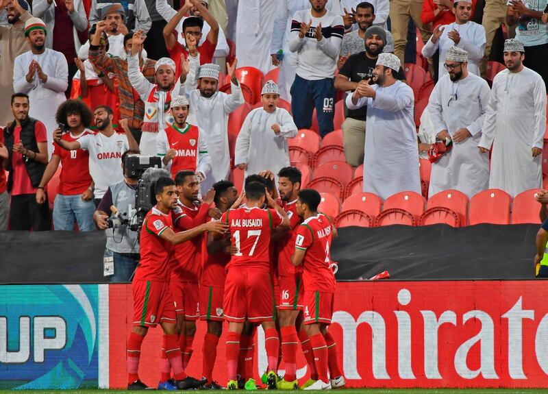 Oman's players celebrate their opening goal during the 2019 AFC Asian Cup group F football match between Oman and Turkmenistan at the Mohammed Bin Zayed Stadium in Abu Dhabi on January 17, 2019.  / AFP / Khaled DESOUKI
