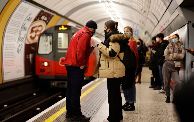 A Transport for London Underground worker advises commuters that a Jubilee Line train is being taken out of service on Friday morning, at Green Park tube station. London Underground services were disrupted after drivers launched a 24-hour strike in a dispute over the Night Tube. AFP