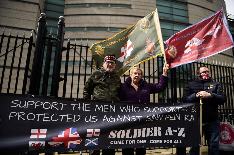 People hold flags and a banner outside Laganside Courts during the trial into the 1972 killing of official IRA member Joe McCann, in Belfast, Northern Ireland, May 4, 2021. REUTERS/Clodagh Kilcoyne