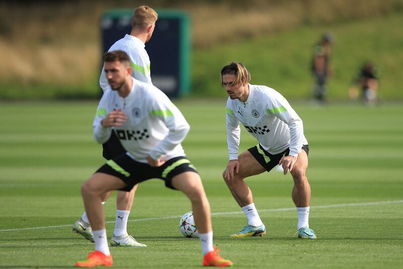 Manchester City midfielder Jack Grealish, right, stretches. AFP