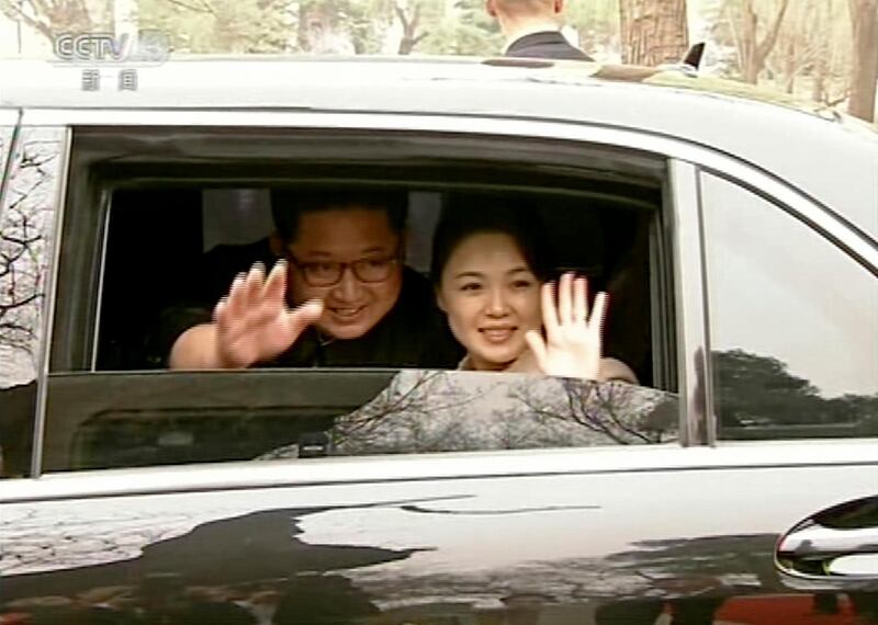 North Korean leader Kim Jong Un, left, and his wife Ri Sol Ju wave from a car as they bid farewell to Chinese counterpart Xi Jinping and his wife Peng Liyuan in Beijing. CCTV via AP Video