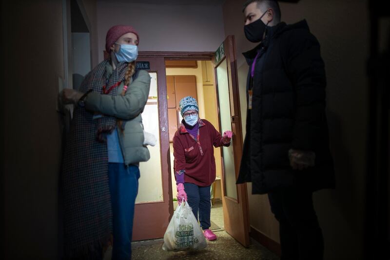 Russian pensioner Galina Prokopieva, 72, picks up a bag with products brought by volunteers in Moscow, Russia. AP Photo