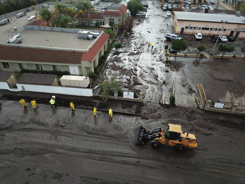 Los Angeles Fire Department Firefighters work admist flood waters and mud after debris flow during heavy rains in Sun Valley, California. Andrew Gombert / EPA