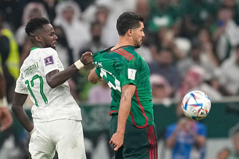 Saudi Arabia's Hassan Tambakti pulls the jersey of Mexico's Henry Martin. AP