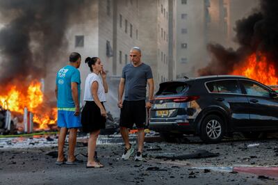 Residents near a fire in Ashkelon, Israel, after rockets were launched from the Gaza Strip on Saturday. Reuters