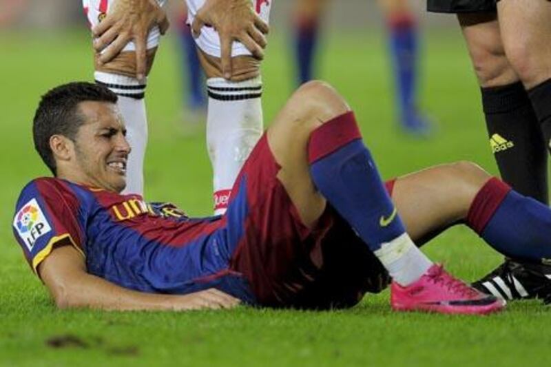 Barcelona's forward Pedro Rodriguez reacts after being injured during their first league football match between Barcelona and Mallorca at Camp Nou Stadium on October 3, 2010 in Barcelona. The game ended in a draw 1-1.     AFP PHOTO/ JOSEP LAGO

