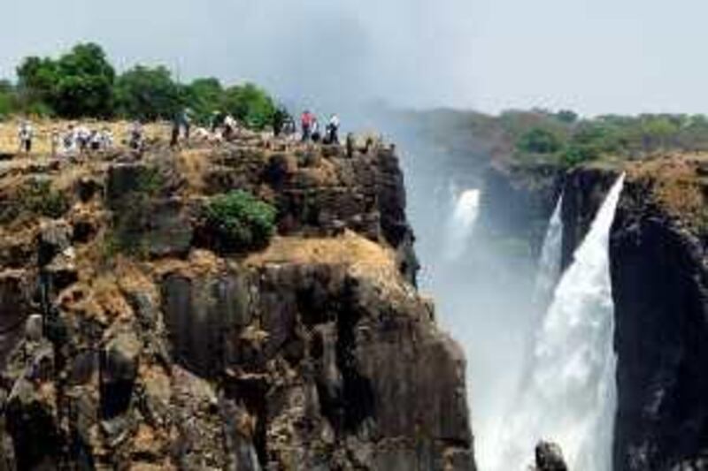 Tourists view the Victoria Falls in Livingstone, Zambia where the 150th anniversary of the discovery of Victoria Falls by Scottish missionary David Livingstone, will be marked with a big splash, that will hopfully draw a record number of tourists. Victoria Falls lies on the border with Zimbabwe but instability there has brought tourists over to the Zambian side to admire one of the world's largest curtains of falling water. The government has launched a "Visit Zambia in 2005" campaign to encourage tourists to join in the festivities next year marking Livingstone's discovery in 1885 of the falls and the 100th anniversary of the foundation of the town of Livingstone. AFP PHOTO /Mackson Wasamunu