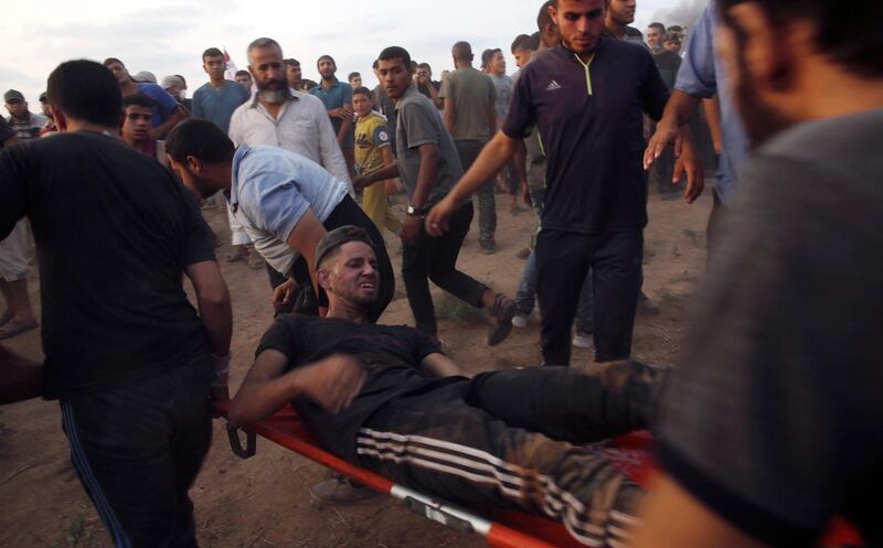 Medics and protesters evacuate a wounded demonstrator near the Gaza Strip border with Israel, during a protest east of Gaza City. AP Photo